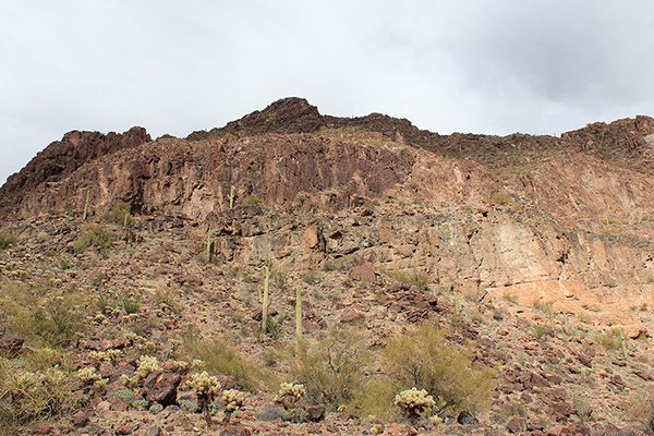 The landmark saguaro is just left of center beneath a cliff in this view